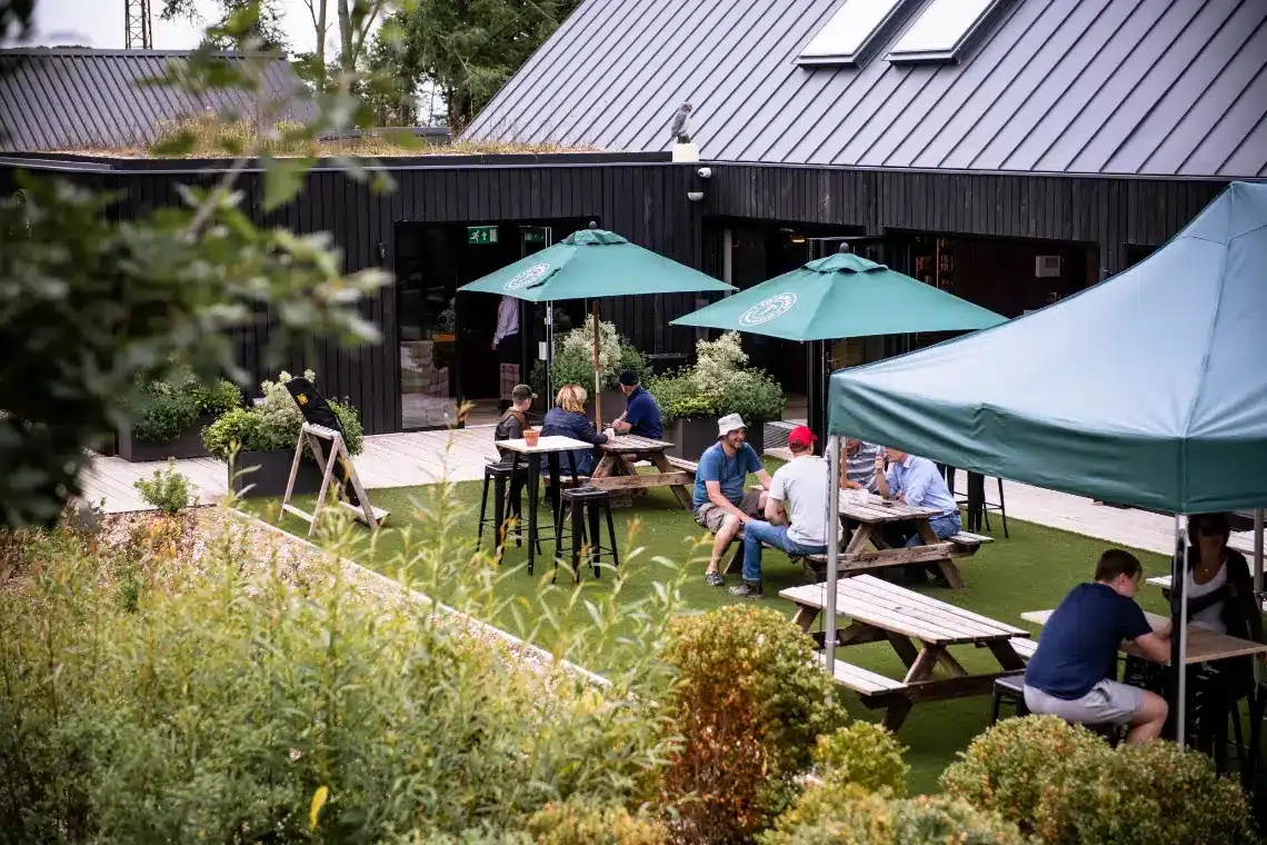 The clubhouse with green umbrellas and people at tables